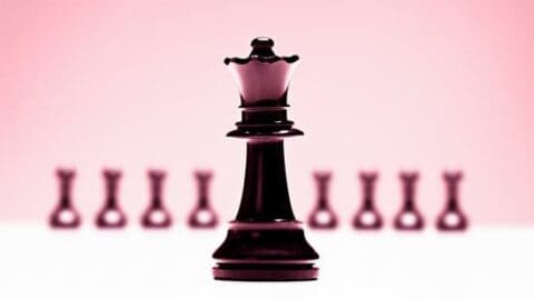 a black and white chess piece on a pink background