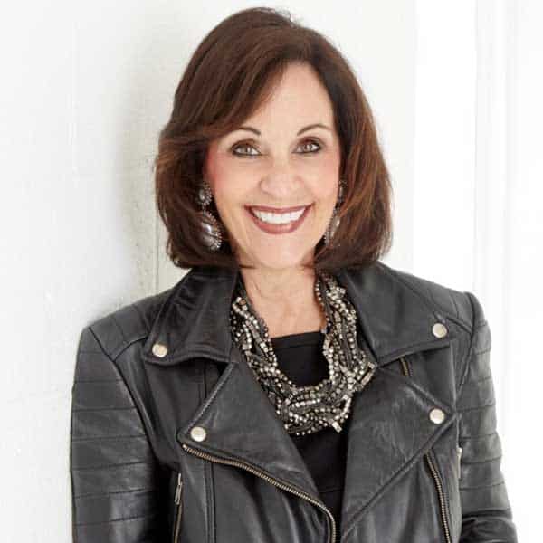 a woman wearing a black leather jacket smiling
