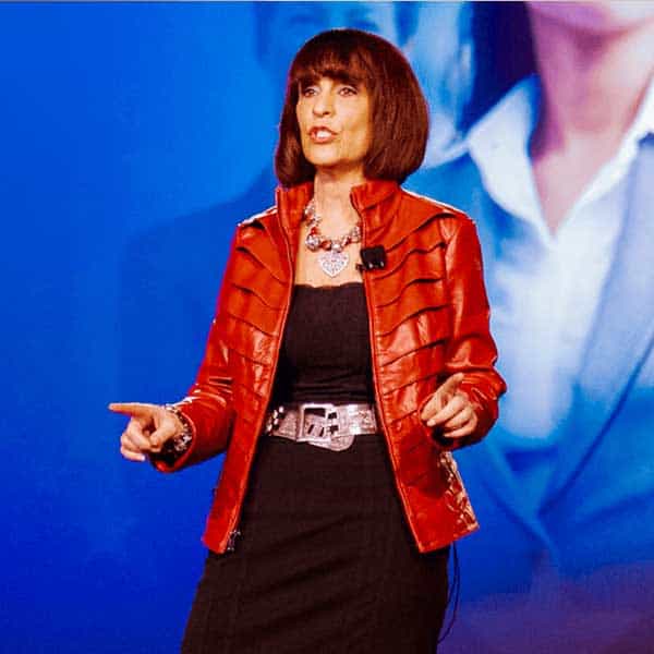 a woman in a red leather jacket talking on stage