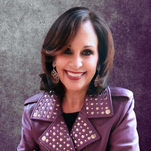 a woman in a purple jacket smiling for the camera