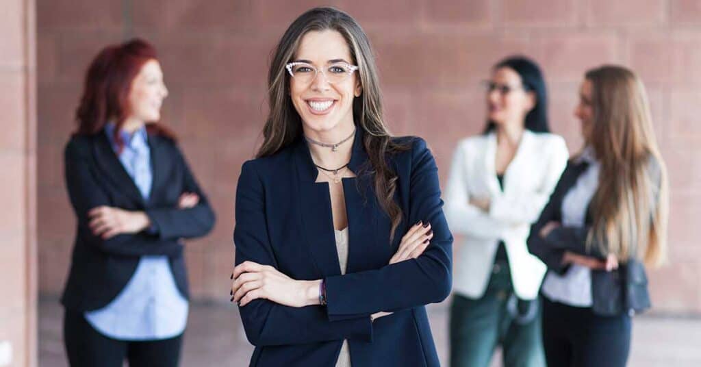 a woman standing in front of a group of women Embracing Authentic Leadership