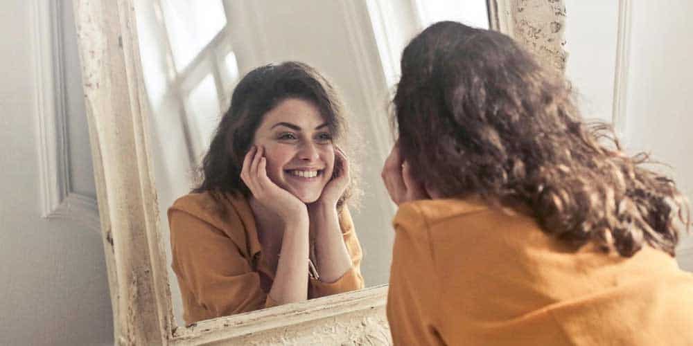 a woman looking at herself in the mirror