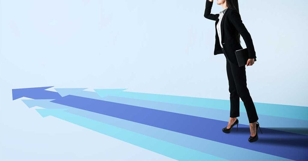Women Leaders Don’t Just Climb The Ladder. They Protect The Pathway. A woman in business attire stands on blue arrows pointing forward, holding a tablet and looking ahead, symbolizing women’s decision-making or future direction.